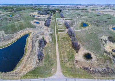 Aerial view of a farm featuring a red barn and a white house surrounded by fields and greenery.