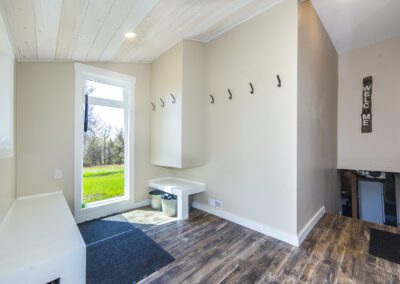 A cozy small house with a spacious deck, nestled beside a flourishing tree, offering a tranquil outdoor space.