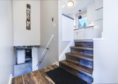 A modern kitchen featuring sleek white cabinets and a stainless steel refrigerator, creating a bright and inviting atmosphere.