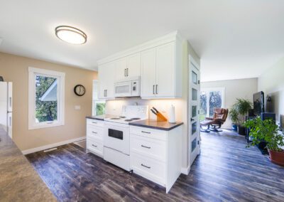 A modern kitchen featuring a white stove and white cabinets, creating a bright and clean cooking space.