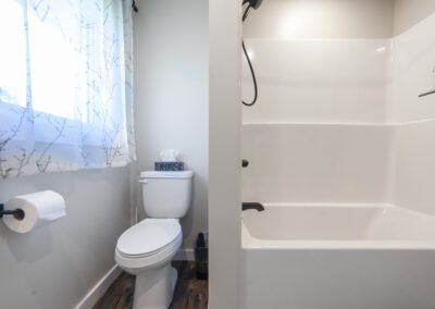 A clean bathroom featuring a toilet, a bathtub, and a shower, showcasing a modern and functional design.