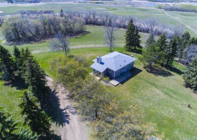 Overhead perspective of a farm showcasing a barn and a house amidst expansive agricultural land.